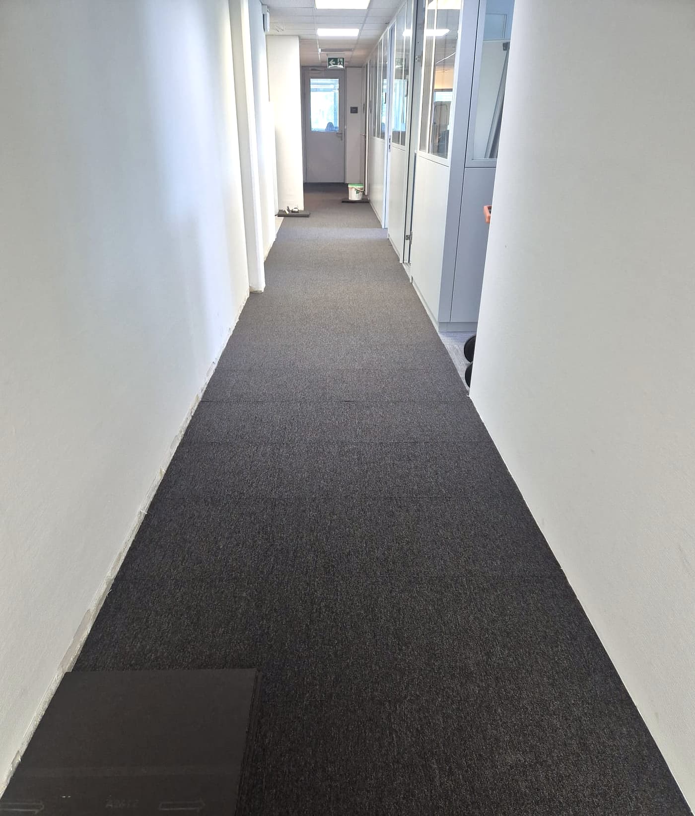 Long couloir de bureaux revêtu de moquette sombre